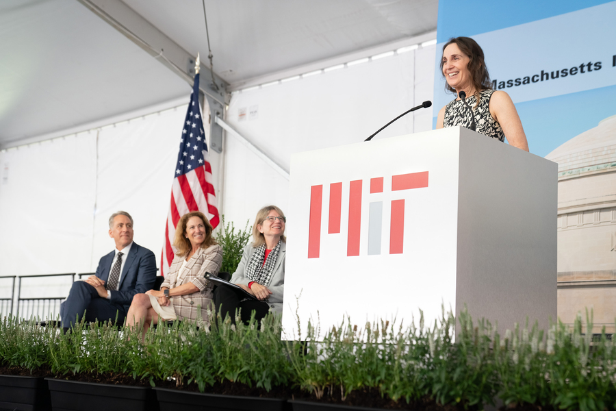Bonnie Berger speaks at the podium as Ian Waits, Cynthia Barnhart, and Sally Kornbluth watch. The podium has an MIT log on it.