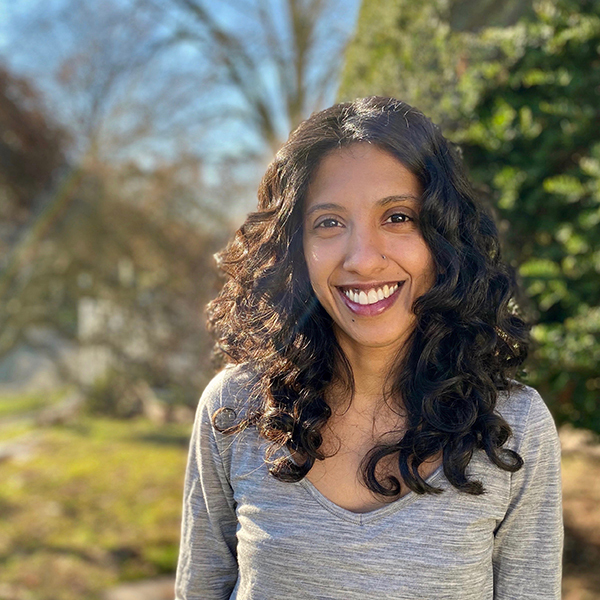 Athulya Aravind smiles against an out-of-focus outdoor background