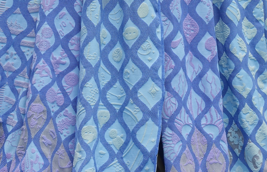 Close-up view of the Living Knitwork panels, showing pictographic stories woven on the surface of the textile panels.