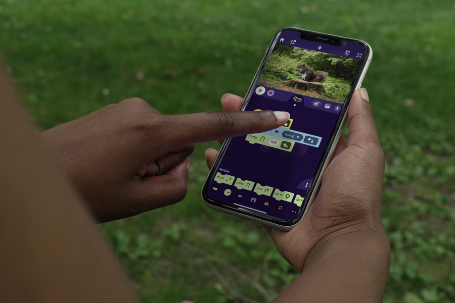 Close-up of two hands holding a smartphone showing a photo of a squirrel and some editing icons