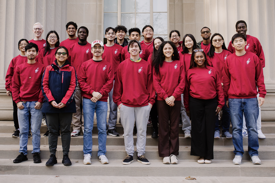 22 students wearing identical red sweatshirts pose for a group photo
