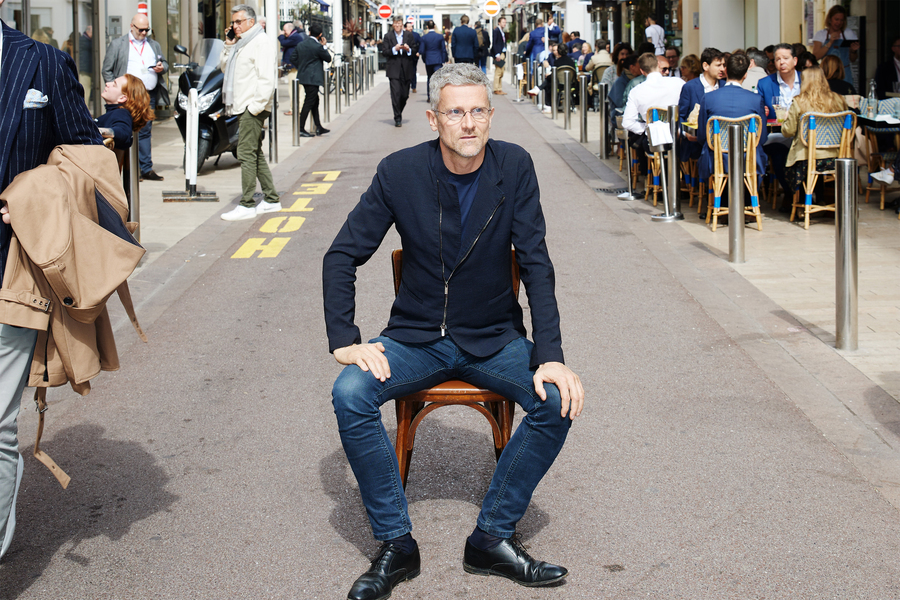 Carlo Ratti sits on chair in middle of busy street outside.