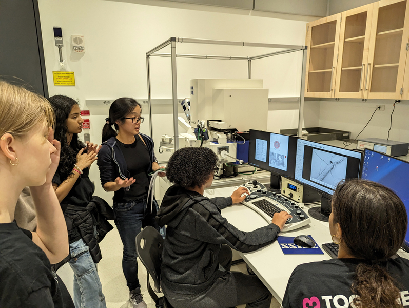 An MIT grad student helps four middle schools explore material samples with an advanced microscope.