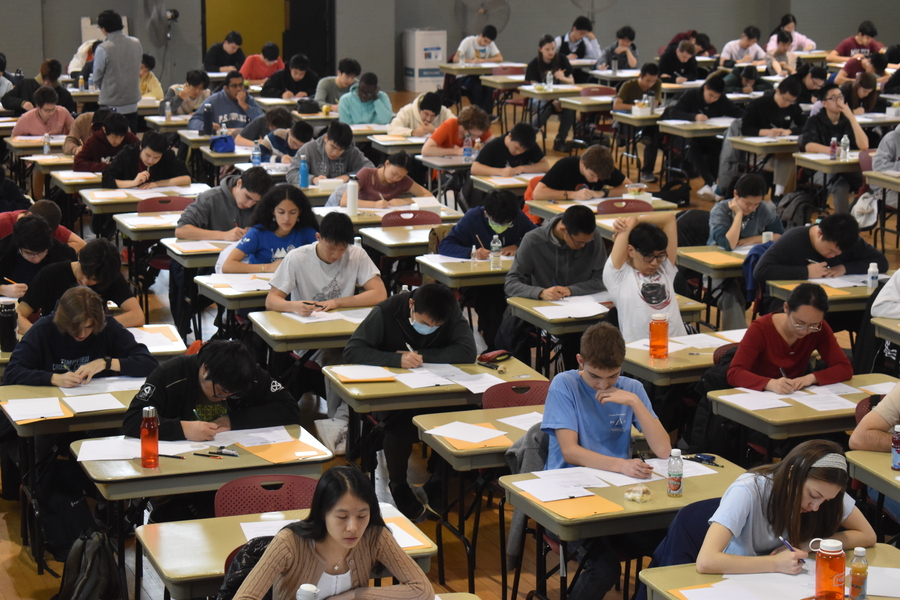 Walker auditorium filled with rows and columns of desks with students taking tests