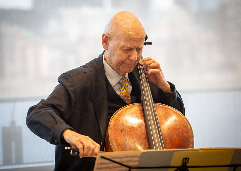 Carlos Prieto sits, playing cello, in a well-lit room
