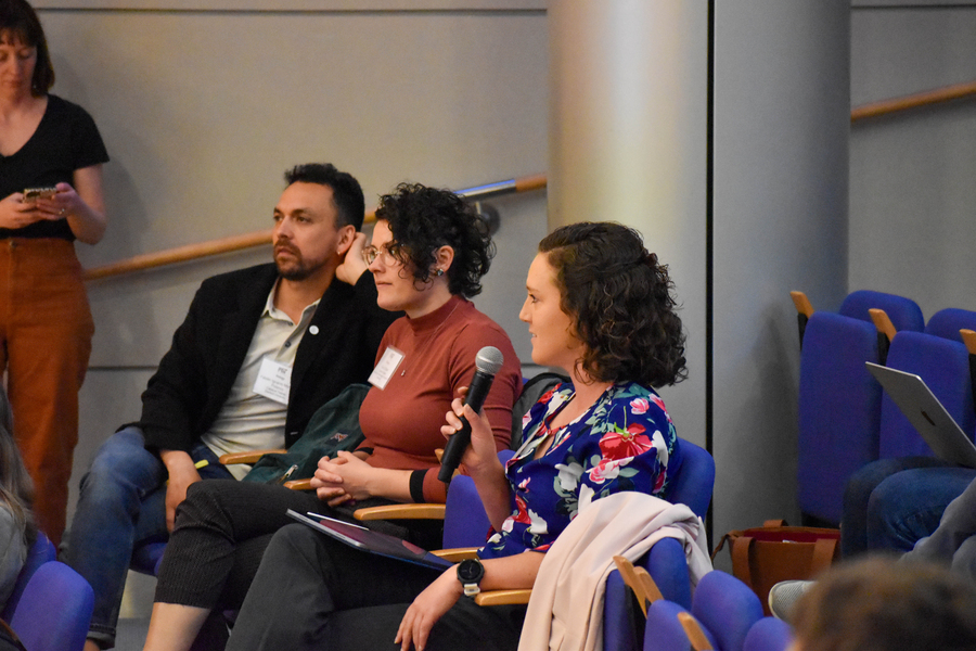 Fabián Morales-Polanco, Kiara Eldred, Kali Pruss sit in chairs, with Pruss holding a microphone