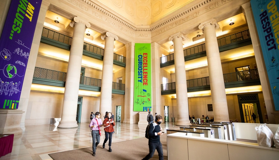 MIT’s main lobby, with a few people walking through it.