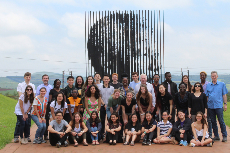 About 35 people pose for a photo outside.
