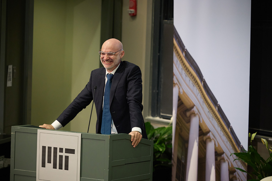 Agustin Rayo speaks, standing behind a lectern.