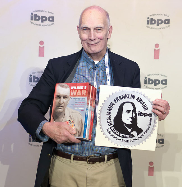 Hale Bradt holding a boxed set of three books and an award certificate.
