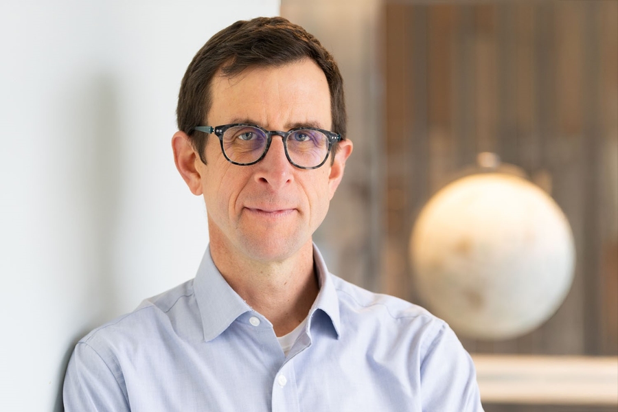 Headshot of David McGee with an out-of-focus globe in the background