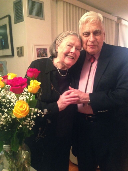 Ruth and Earle Lomon pose in their home, with flowers in the foreground
