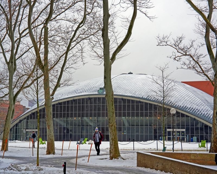A photo of Kresge Auditorium covered in snow with students walking in winter jackets.