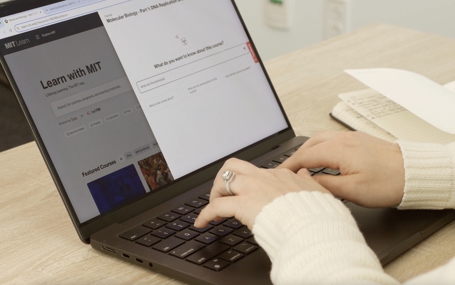 Hands typing on a laptop displaying the MIT Learn homepage