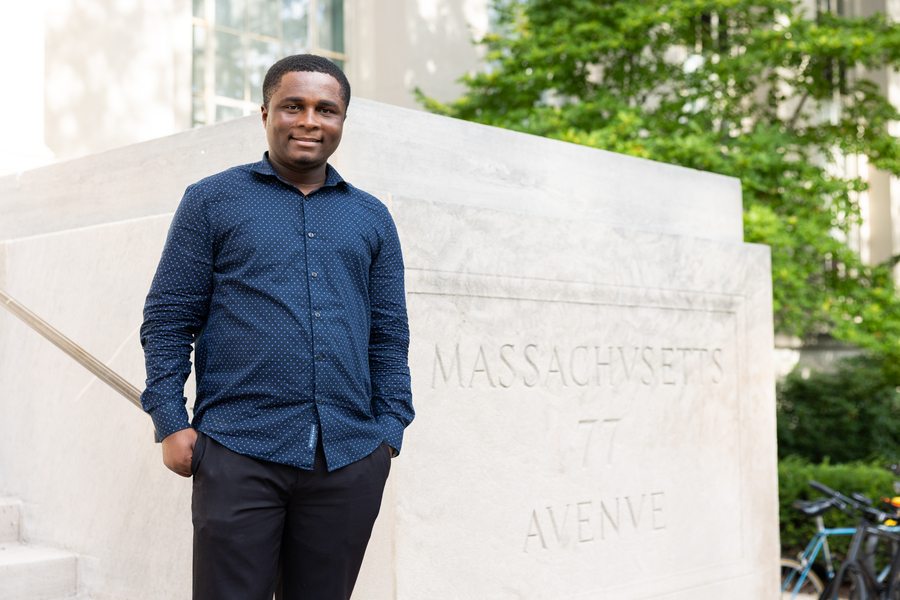 Ernest Opoku poses next to an MIT building entrance at 77 Mass. Ave.