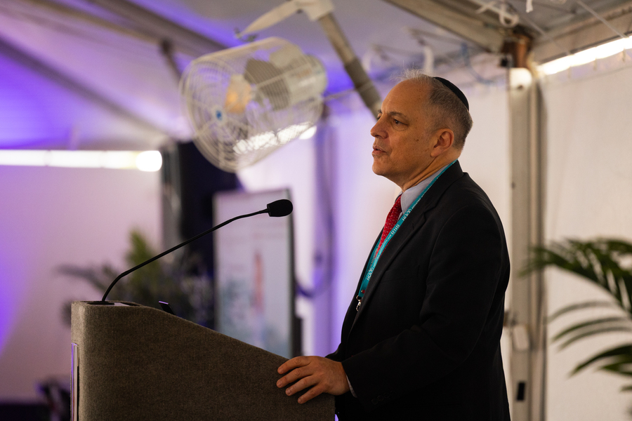 Profile view of a man speaking at a lectern