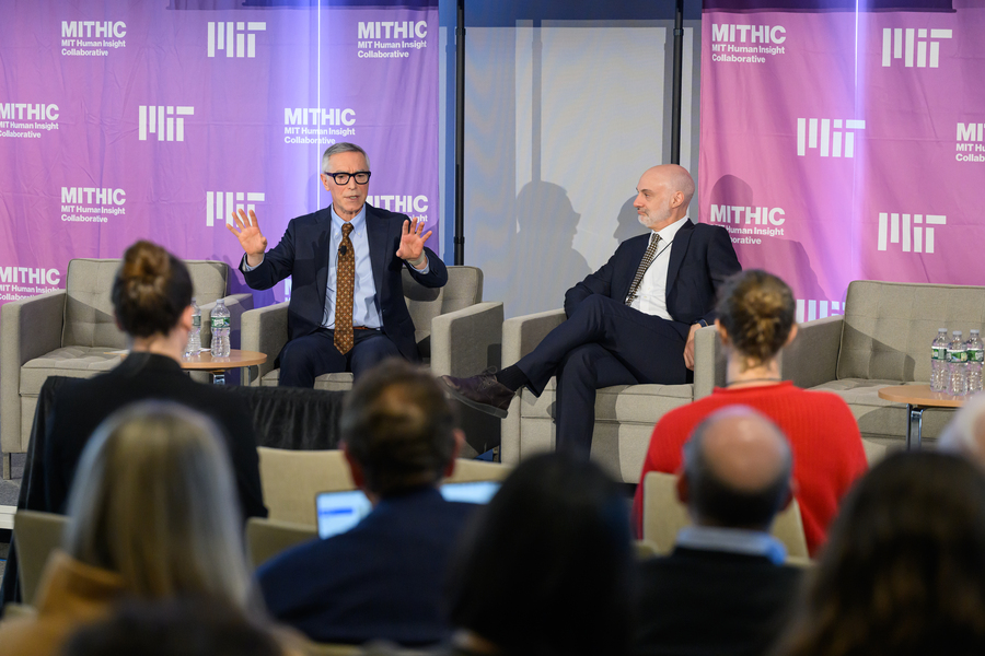 Rick Locke and Agustín Rayo, both seated, talk with one another in front of an audience. The term “MIT Human Insight Collaborative" is in the background