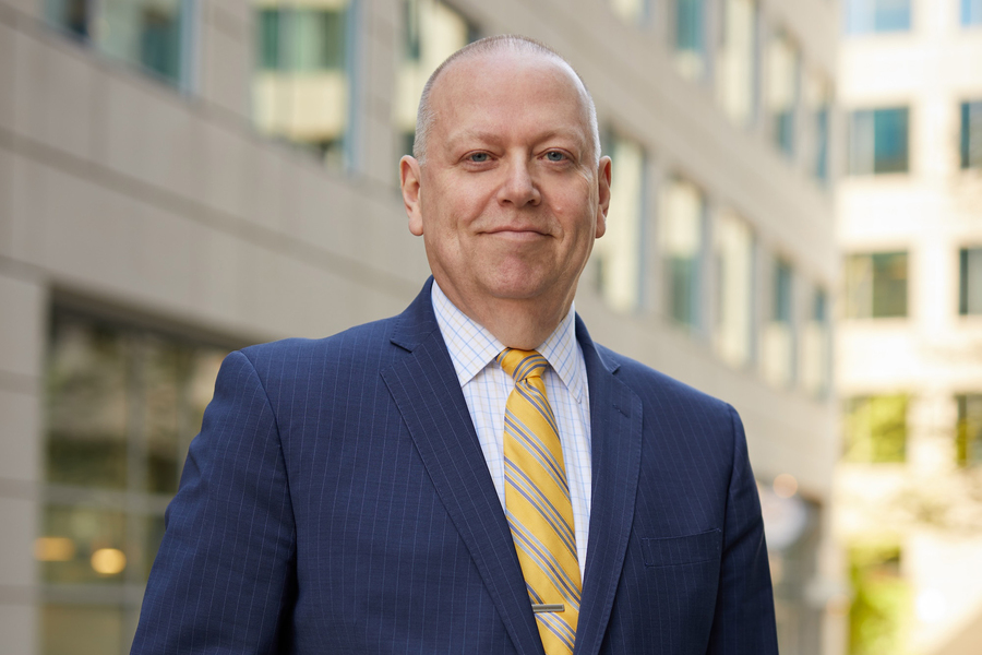 Michael Moody stands outside an office building on a sunny day