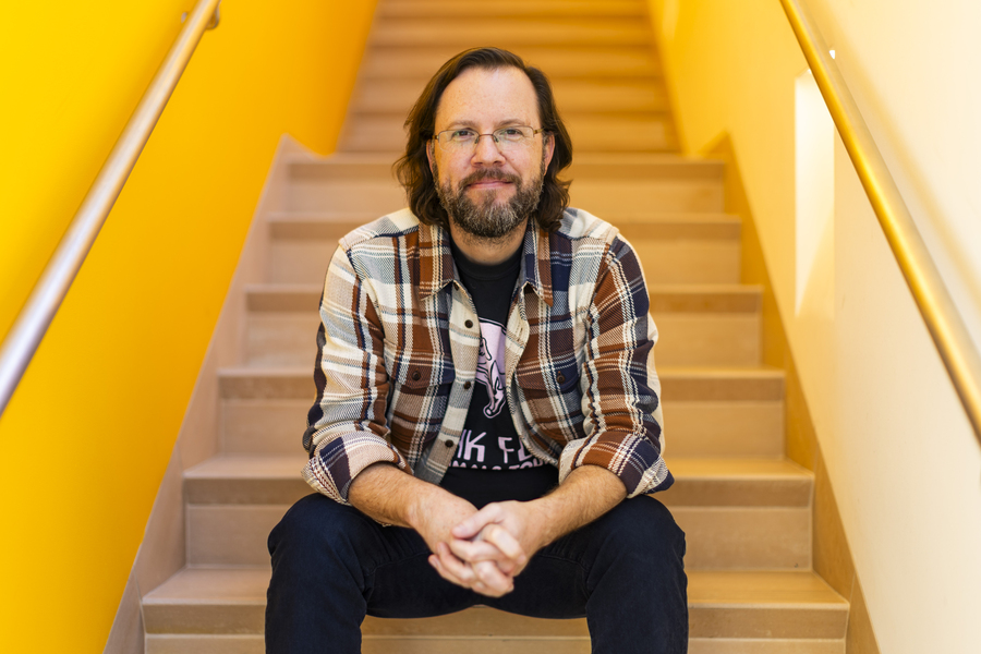 Profile photo of Mark Harnett sitting on an indoor stairwell