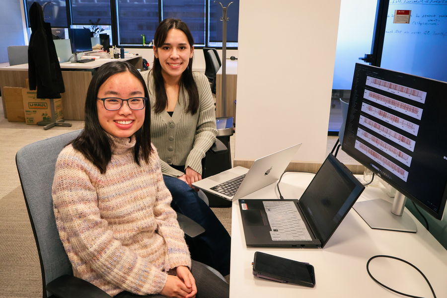 Tiffany Yau and Teya Bergamaschi sit together in front of a laptop and a monitor that displays ECG data.