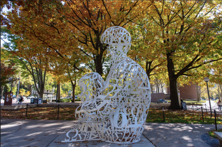 The Alchemist sculpture surrounded by autumn trees