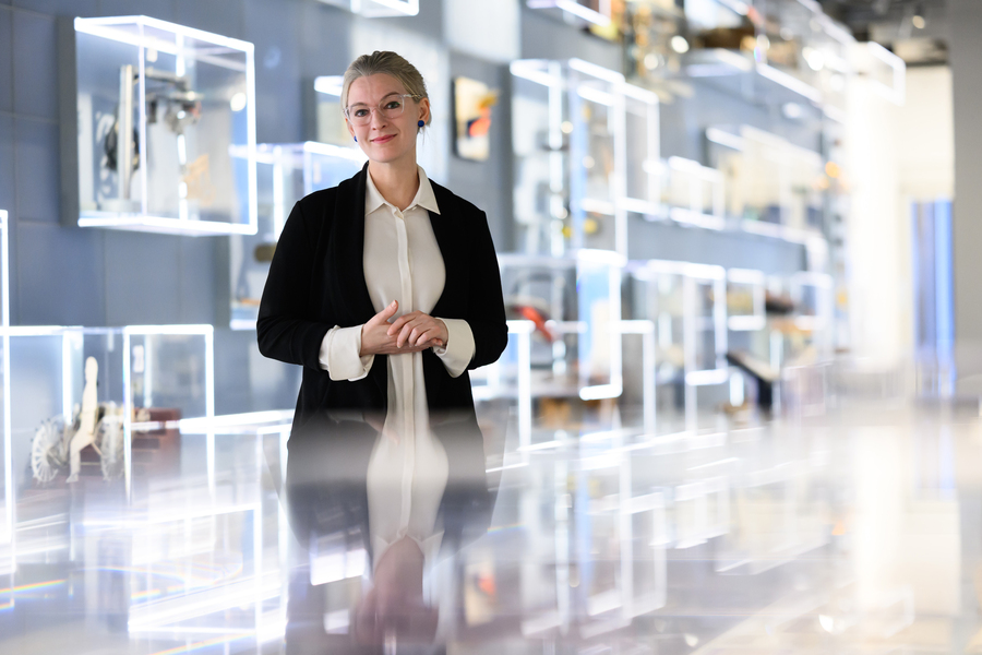 Amy Moran-Thomas at MIT Museum with reflective glass cases.