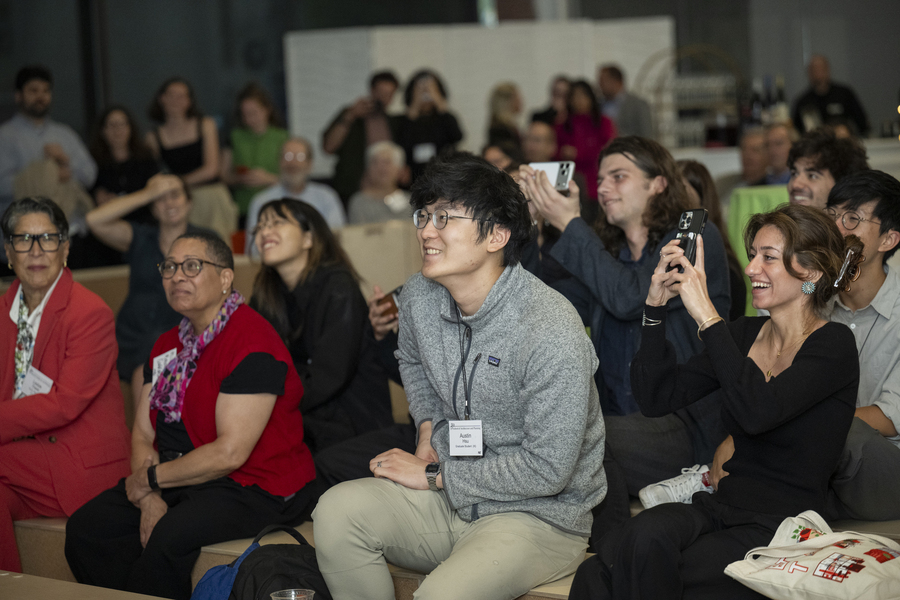 Audience members smile and take photos at the event.