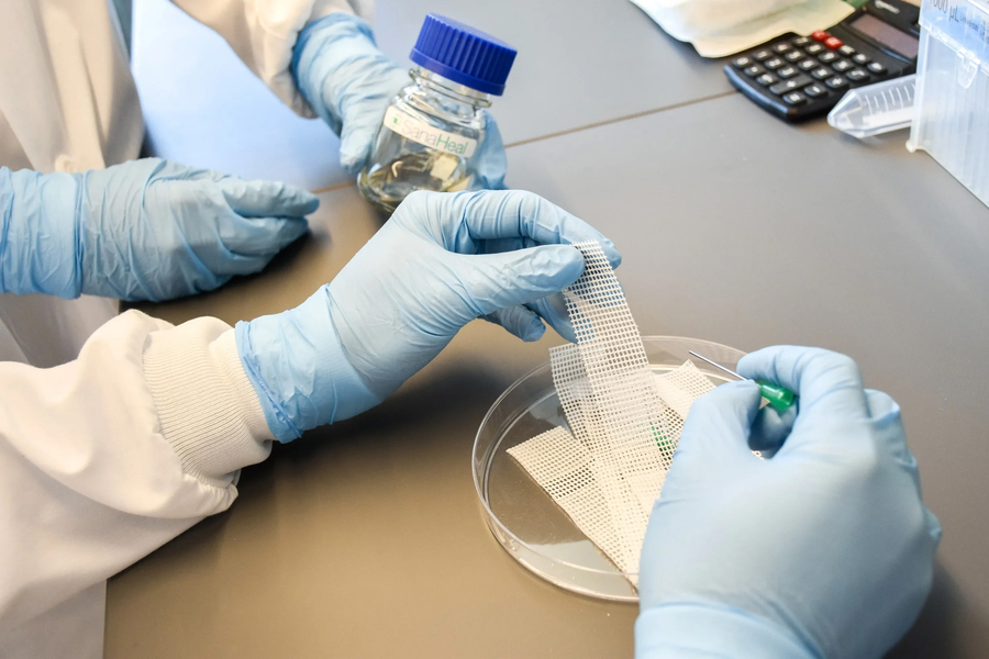  A lab worker handling a piece of mesh