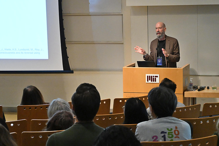 Earl Miller stands behind an MIT-labeled lectern indoors