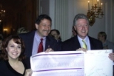 Professor Eric Lander (center), director of the Whitehead/MIT Center for Genome Research, and Lauren Linton, co-director of the Genome Center's sequencing center, presented President Clinton with a printout of human DNA sequence trace signed by all the Genome Center members.