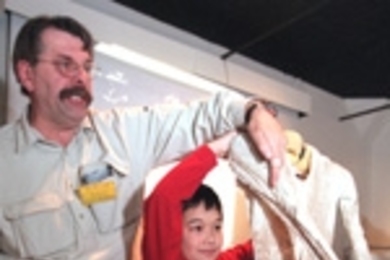 Ryan Pradit, 9, of Portsmouth, NH, holds the internal part of an actual NASA spacesuit while Donald W. Rethke ("Dr. Flush") explains how the tube-filled suit works to keep an astronant both warm and cool at the same time.