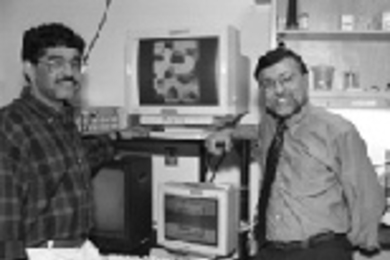 Dr. Jitendra Sharma (left) and Professor Mriganka Sur, head of the Department of Brain and Cognitive Sciences, stand next to laboratory monitors showing data on brain activity.