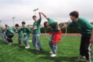 "They Might be Tools," a Johnson Games team sponsored by the Women's Independent Living Group, works together to move hula hoops down the line.