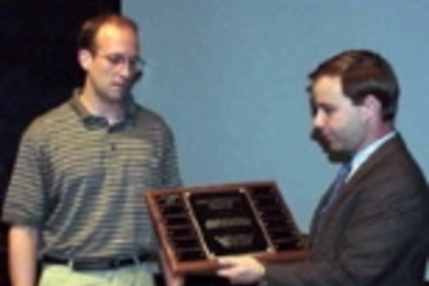 Terence Emert (left) prepares to receive the Charles "Harrison" Smith III Memorial Award from LFM student Rob Mosher, a friend of the late Mr. Smith