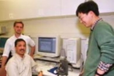 James Biggs, postdoctoral associate in the Research Lab of Electronics (left), Professor Mandayam Srinivasan, director of MIT's Touch Lab, and mechanical engineering graduate student Jung Kim observe the movement of a robotic arm driven by signals from a monkey at Duke University.