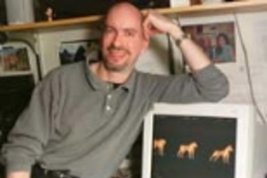 Associate Professor Earl K. Miller with computer monitor images of morphing dogs and cats that monkeys are able to categorize.