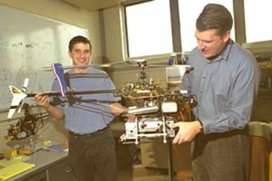 Graduate student Ioannis Martinos and Professor Eric Feron of the Department of Aeronautics and Astronautics hold the robotic helicopter they helped develop.