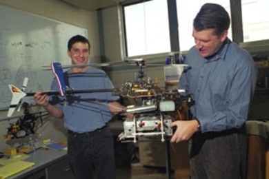 Graduate student Ioannis Martinos (left) and Professor Eric Feron hold the robotic helicopter they helped develop.