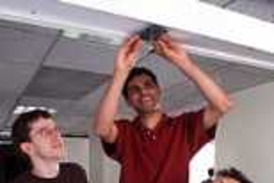 Robert Morris, Hari Balakrishnan and Frans Kaashoek,  faculty in the Laboratory for Computer Science, attach a low-cost beacon for Project  Oxygen's Cricket Indoor Location System.