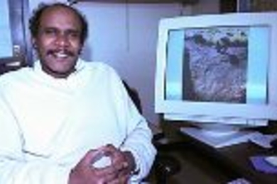 Professor Elfatih Eltahir of civil and environmental engineering sits by a monitor showing rock art of a giraffe carved thousands of years ago when portions of the Sahara were still green.