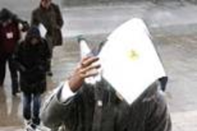 Unidentified woman tries to shield herself from the elements as she approaches the main entrance to MIT.