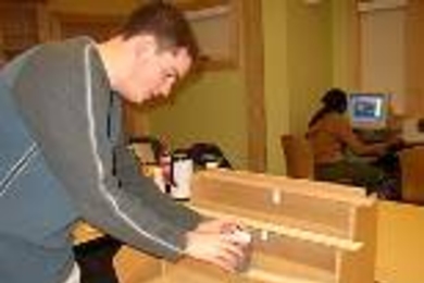 Will Etheridge sets up a beam-bending demonstration using a solid piece of wood (top), five bonded wooden strips (middle) and five unbonded strips.