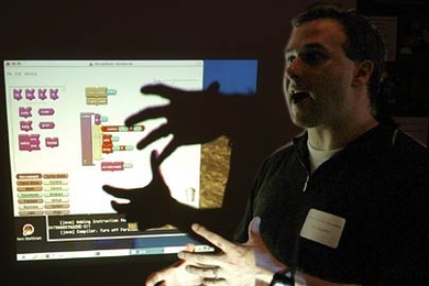 At the Educational Technology Fair, Professor Eric Klopfer of urban studies and planning gestures in front of his computer screen as he describes how he integrates handheld devices into his courses.