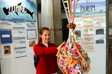 Freshman Lissa Riley, who traveled to the Galapagos Islands as part of MIT's Terrascope program, works on a knot displayed in the lobby of Building 13 as a metaphor for the complexity of pleasing all of the stakeholders in the Galapagos, from residents to tourists and from the government to the ecosystem.