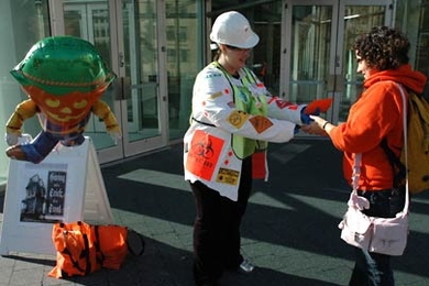 Community Giving volunteer Melissa Kavlakli, in hard hat, offers Cristina Ximenes some candy and a reminder about MIT's annual Community Giving Campaign outside the Stata Center 77 Mass. Ave. on Monday, Oct. 31. "Helping people can be a real screeeeam!" the card said.