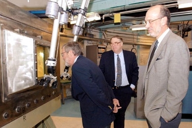 Nuclear Regulatory Commissioner Peter Lyons peers into a 'hot cell' (a shielded room where radioactive materials can be handled remotely) on a tour of the nuclear reactor on Tuesday, Feb. 28. At center is John Bernard, director of reactor operations at the MIT Nuclear Reactor Laboratory, and at right is David Moncton, director of the Nuclear Reactor Lab.