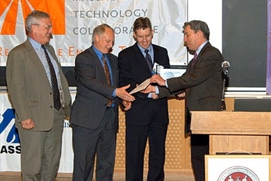 Warren Leon presents the top prize in the 2006 Ignite Clean Energy Business Presentation Competition to representatives of Stellaris, from left, Jim Paull, president and co-founder; Tom Ward, vice president; and Lee Johnson, chief operating officer and co-founder.
