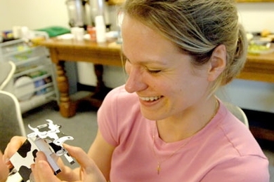 Tara Tetreault, science teacher at the Ahearn Middle School in Foxboro, proudly checks out the cow she made July 12 in a workshop on making paper mechanical sculptures, held at the MIT Museum as part of the Museum Institute for Teaching Science.