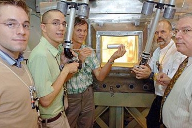 MIT researchers working on the next generation of nuclear technology test-fit a prototype fuel capsule using the manipulators of a hot box at MIT's Research Reactor.