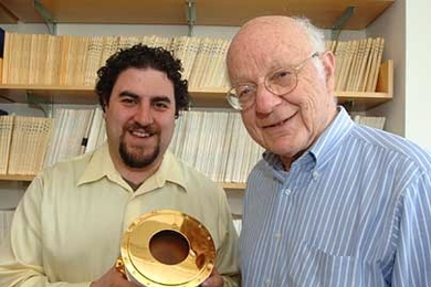 Research scientists Justin Kasper and Alan Lazarus display a Faraday Cup, a device used to measure the current in a beam of charged particles.